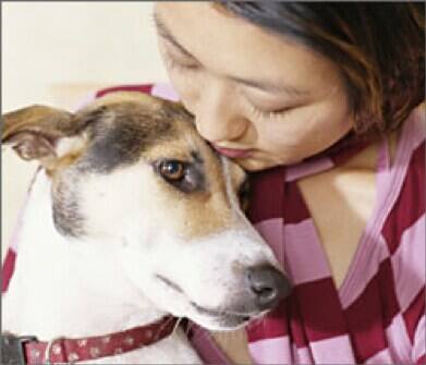 mujer sujetando un perro con collar rojo
